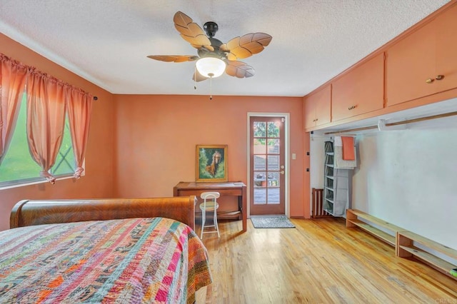 bedroom featuring ceiling fan, a textured ceiling, access to exterior, and light wood-type flooring