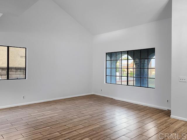 spare room featuring light hardwood / wood-style flooring and high vaulted ceiling