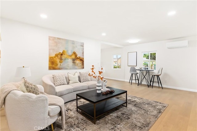 living room featuring an AC wall unit and light hardwood / wood-style flooring