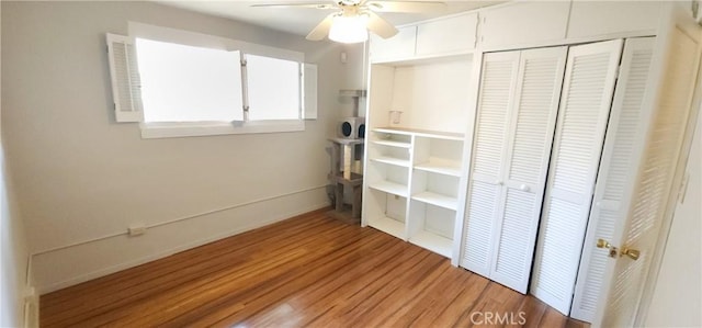 unfurnished bedroom with ceiling fan, wood-type flooring, and a closet