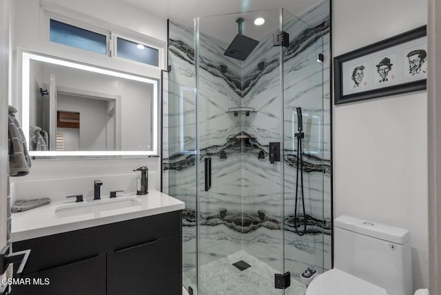 bathroom featuring vanity, toilet, and a shower with shower door