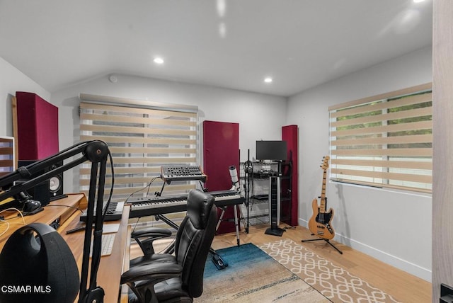 workout room with lofted ceiling and light wood-type flooring