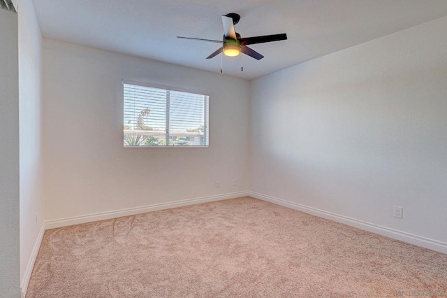 spare room with ceiling fan and light carpet