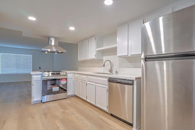 kitchen with white cabinetry, sink, stainless steel appliances, and wall chimney range hood