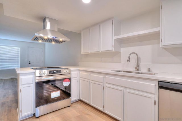 kitchen with white cabinetry, sink, wall chimney exhaust hood, stainless steel appliances, and light hardwood / wood-style floors