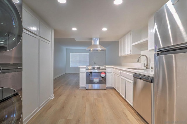 kitchen with wall chimney exhaust hood, stainless steel appliances, sink, light hardwood / wood-style floors, and white cabinetry