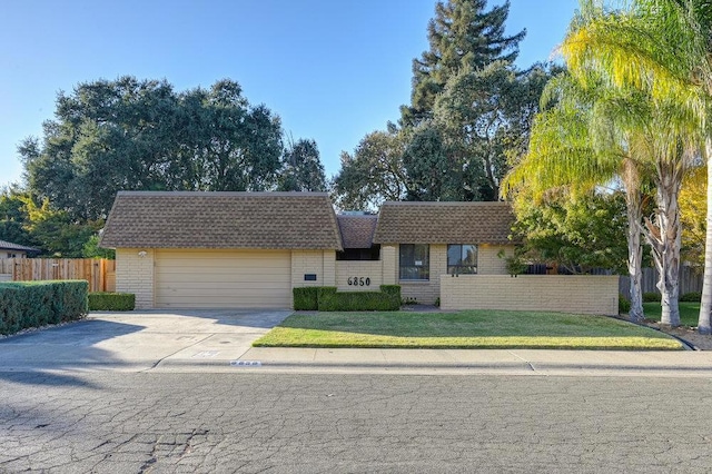 ranch-style home with a front lawn and a garage