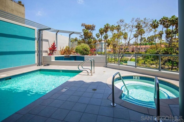 view of swimming pool with an in ground hot tub