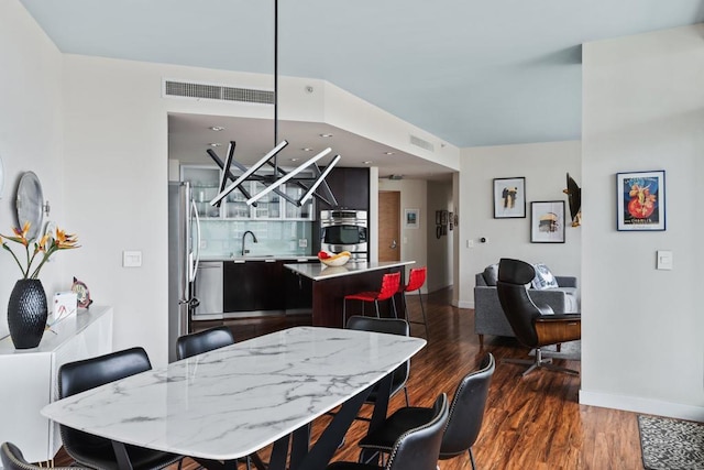 dining space featuring sink and dark wood-type flooring