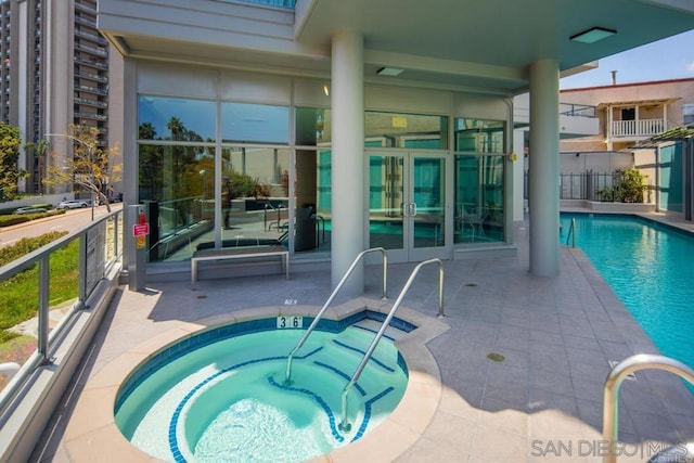 view of pool featuring french doors, a patio, and a community hot tub