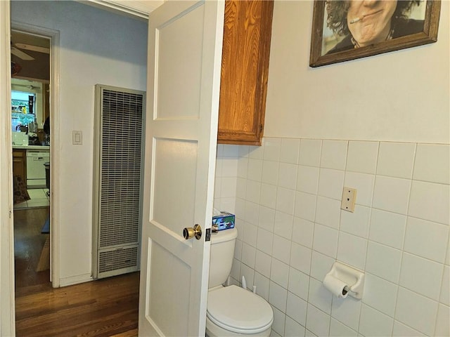 bathroom with hardwood / wood-style floors, toilet, and tile walls