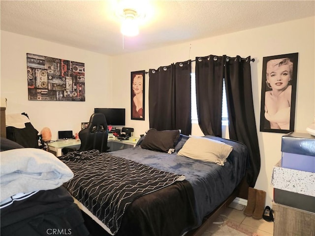 bedroom featuring light tile patterned floors and a textured ceiling