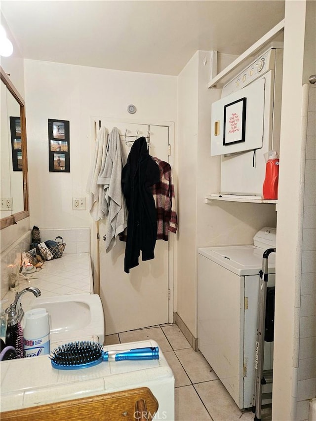 washroom with light tile patterned floors, sink, and washer / clothes dryer