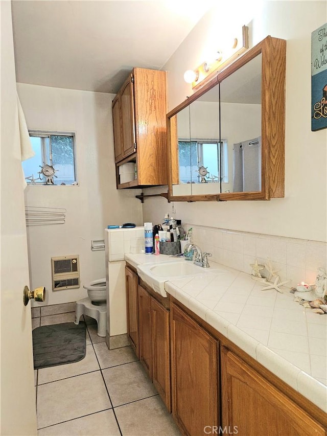 bathroom featuring tile patterned floors, heating unit, plenty of natural light, and toilet