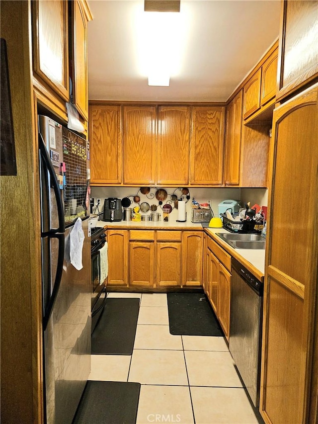 kitchen featuring appliances with stainless steel finishes, light tile patterned floors, and sink