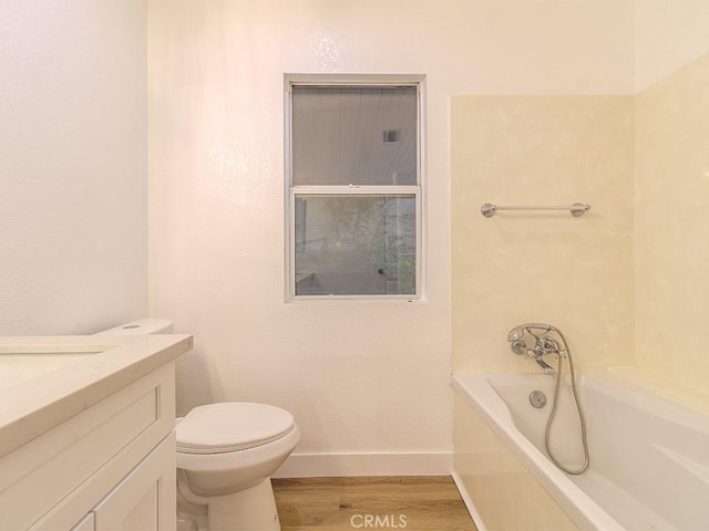 bathroom featuring a tub, toilet, vanity, and hardwood / wood-style flooring