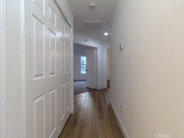 corridor with dark hardwood / wood-style flooring