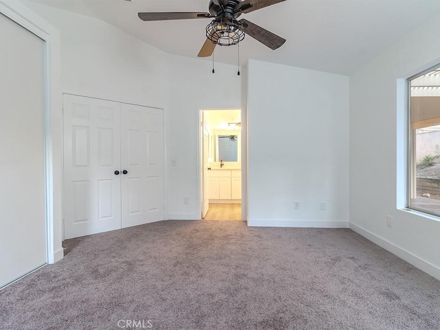 unfurnished bedroom featuring carpet flooring, ceiling fan, a closet, and vaulted ceiling