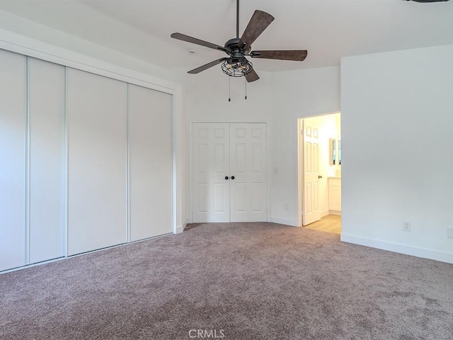 unfurnished bedroom with ensuite bath, ceiling fan, and light carpet