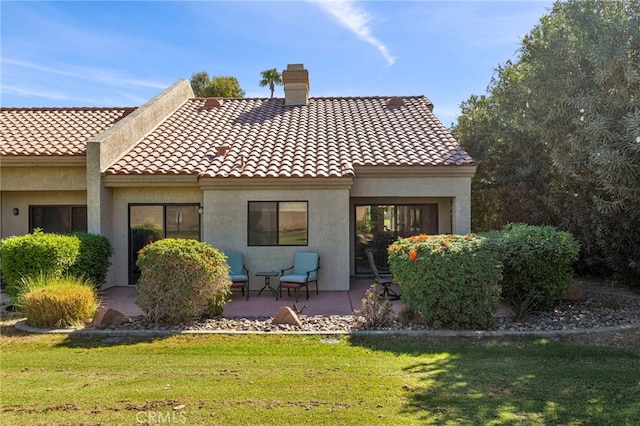 rear view of property featuring a lawn and a patio