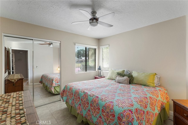 tiled bedroom with ceiling fan, a closet, and a textured ceiling