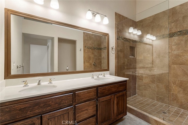 bathroom with a tile shower and vanity