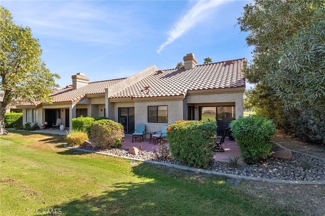 rear view of house featuring a yard and a patio