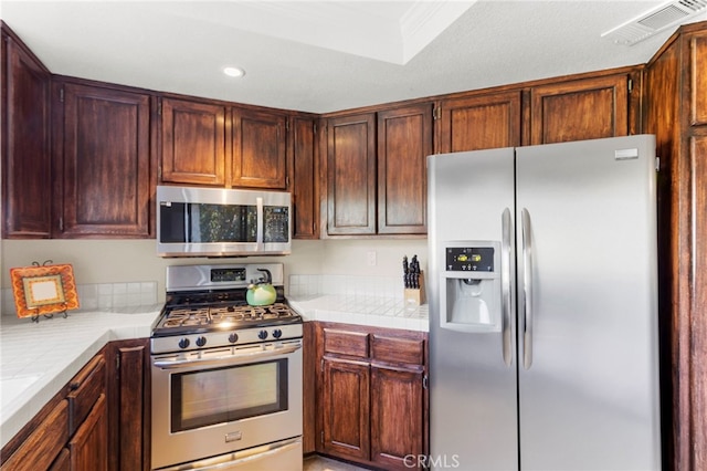 kitchen featuring tile countertops and stainless steel appliances