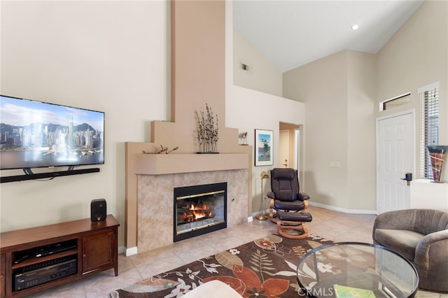 tiled living room featuring a high end fireplace and high vaulted ceiling