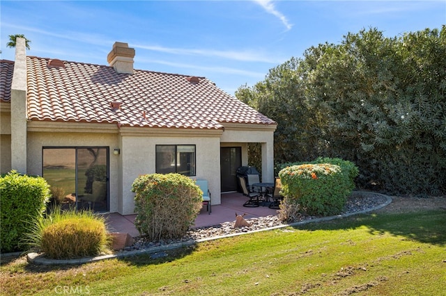 rear view of property with a yard and a patio