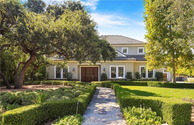 view of property hidden behind natural elements featuring a garage