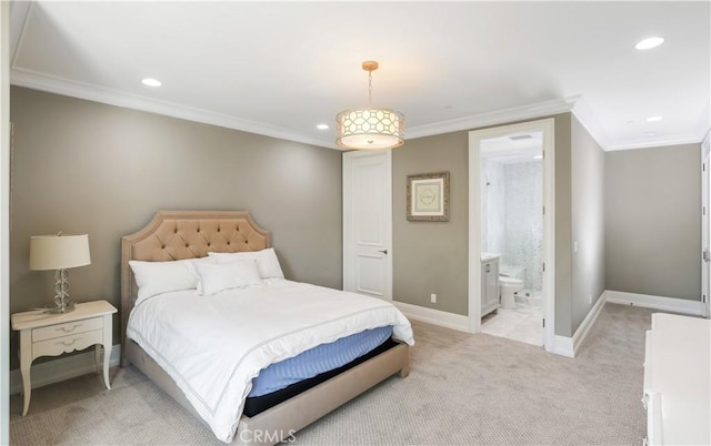 carpeted bedroom with ornamental molding and ensuite bath