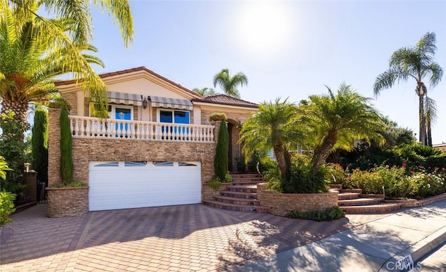 mediterranean / spanish home featuring a garage and a balcony