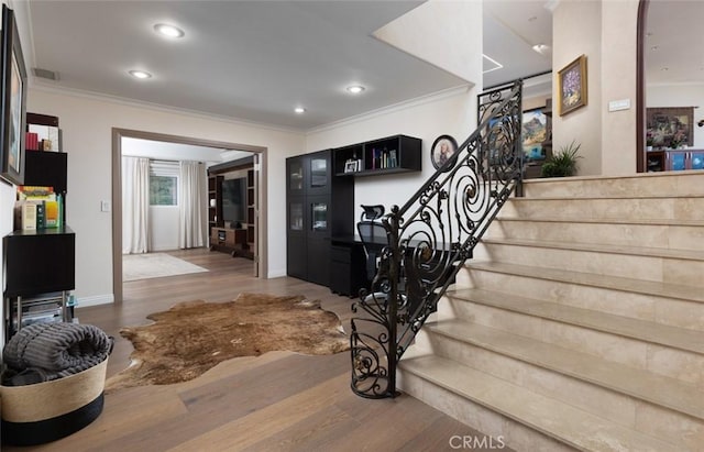 stairway with ornamental molding and wood-type flooring