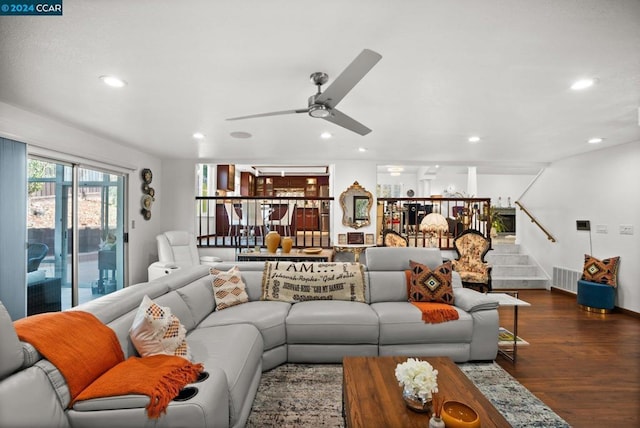 living room featuring ceiling fan and dark hardwood / wood-style floors