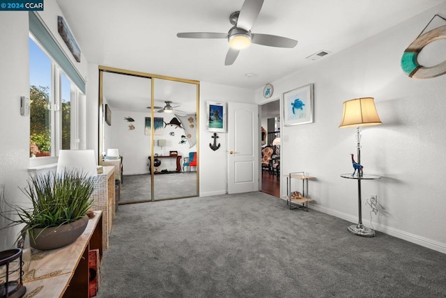 interior space featuring ceiling fan and dark colored carpet