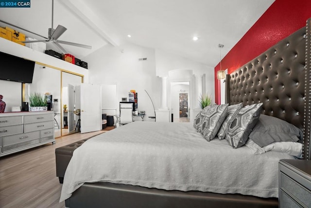 bedroom featuring ceiling fan, hardwood / wood-style floors, beamed ceiling, a closet, and decorative columns