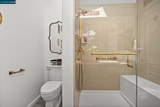 bathroom with a shower with shower door and toilet