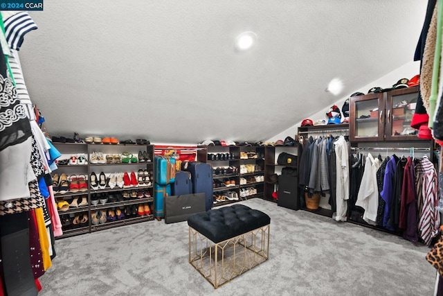 spacious closet featuring lofted ceiling and light colored carpet