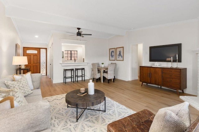 living room featuring light hardwood / wood-style floors, ceiling fan, and crown molding