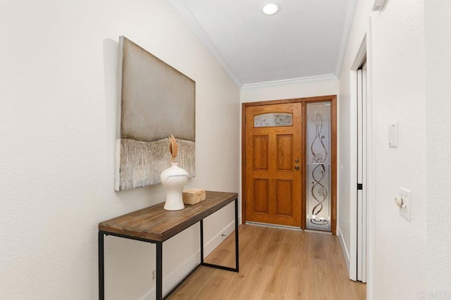 doorway featuring crown molding and light hardwood / wood-style floors