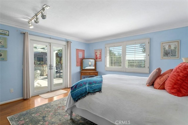 bedroom with hardwood / wood-style floors, access to exterior, french doors, and multiple windows