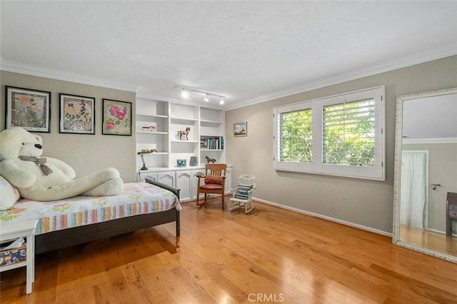 bedroom featuring crown molding, light hardwood / wood-style flooring, and rail lighting