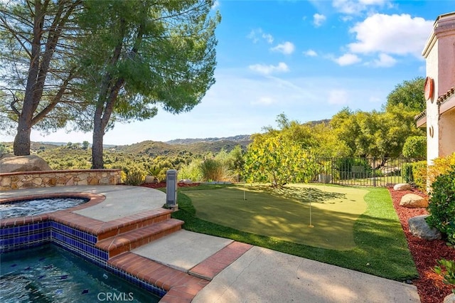 exterior space with a mountain view and a swimming pool with hot tub