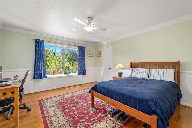 bedroom featuring hardwood / wood-style floors, ceiling fan, and ornamental molding