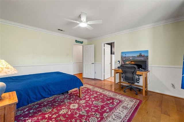 bedroom featuring ceiling fan, crown molding, and wood-type flooring