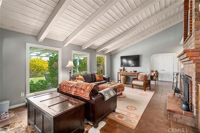 living room with vaulted ceiling with beams and a fireplace