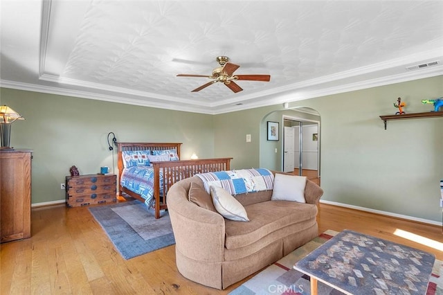 bedroom featuring ceiling fan, wood-type flooring, and ornamental molding