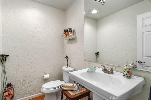 bathroom featuring hardwood / wood-style flooring, toilet, and sink