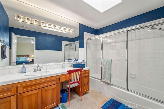 bathroom featuring tile patterned flooring, ceiling fan, shower / bath combination with glass door, and vanity